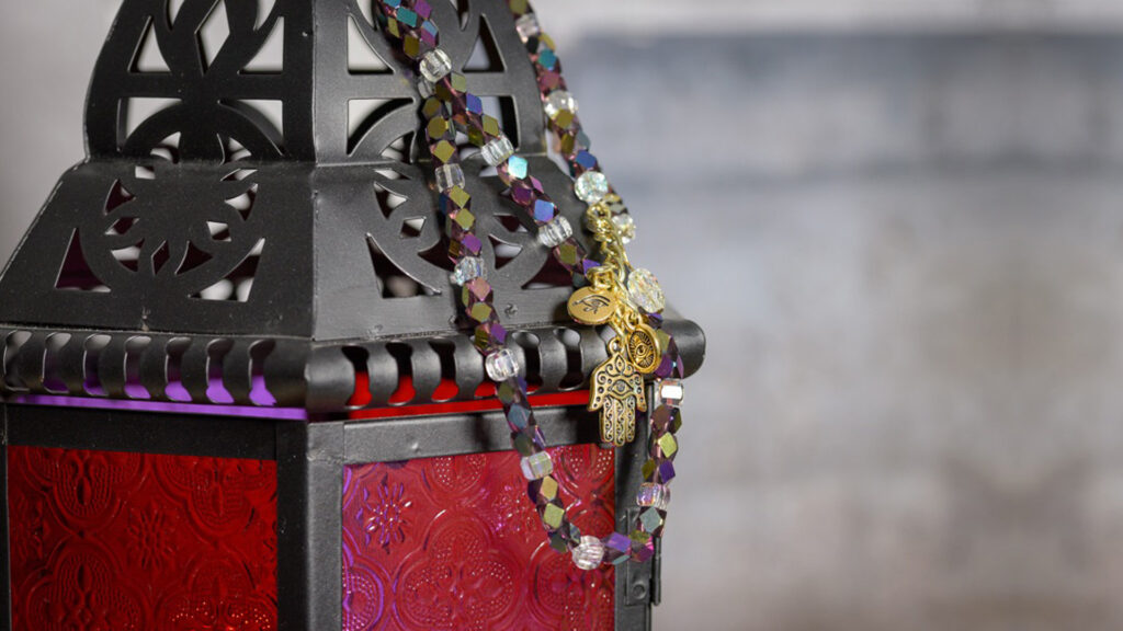 Khamsa BellyBelt with colourful beads and a gold Khamsa and evil eye pendent hanging on a lantern.