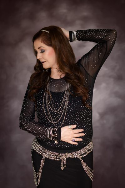 Leanna wearing a belly belt with a black and gold outfit